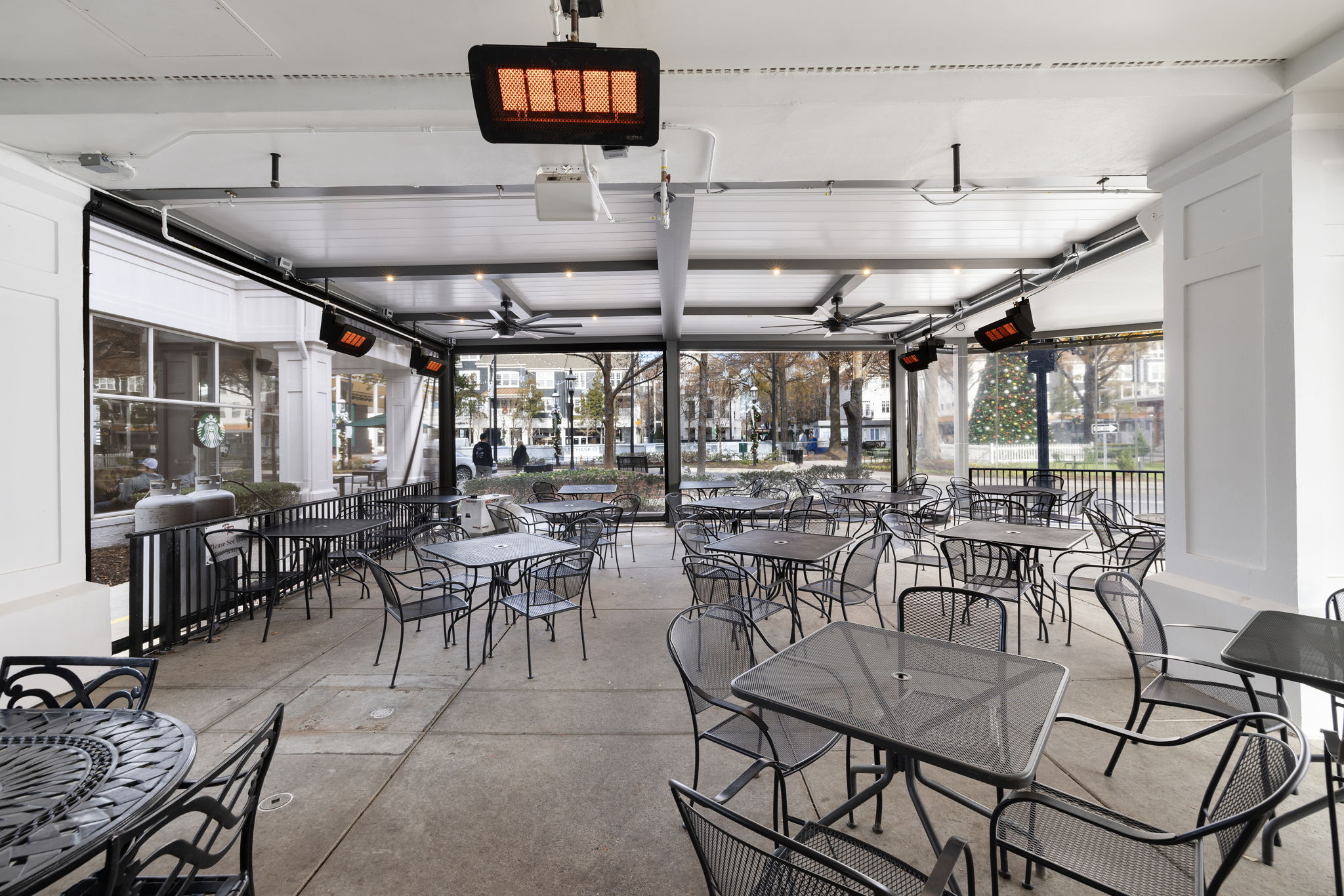 Gray-bronze Azenco R-BLADE pergola with white louvers, fans, recessed lights and heaters — all-season hospitality build-out on a commercial patio.