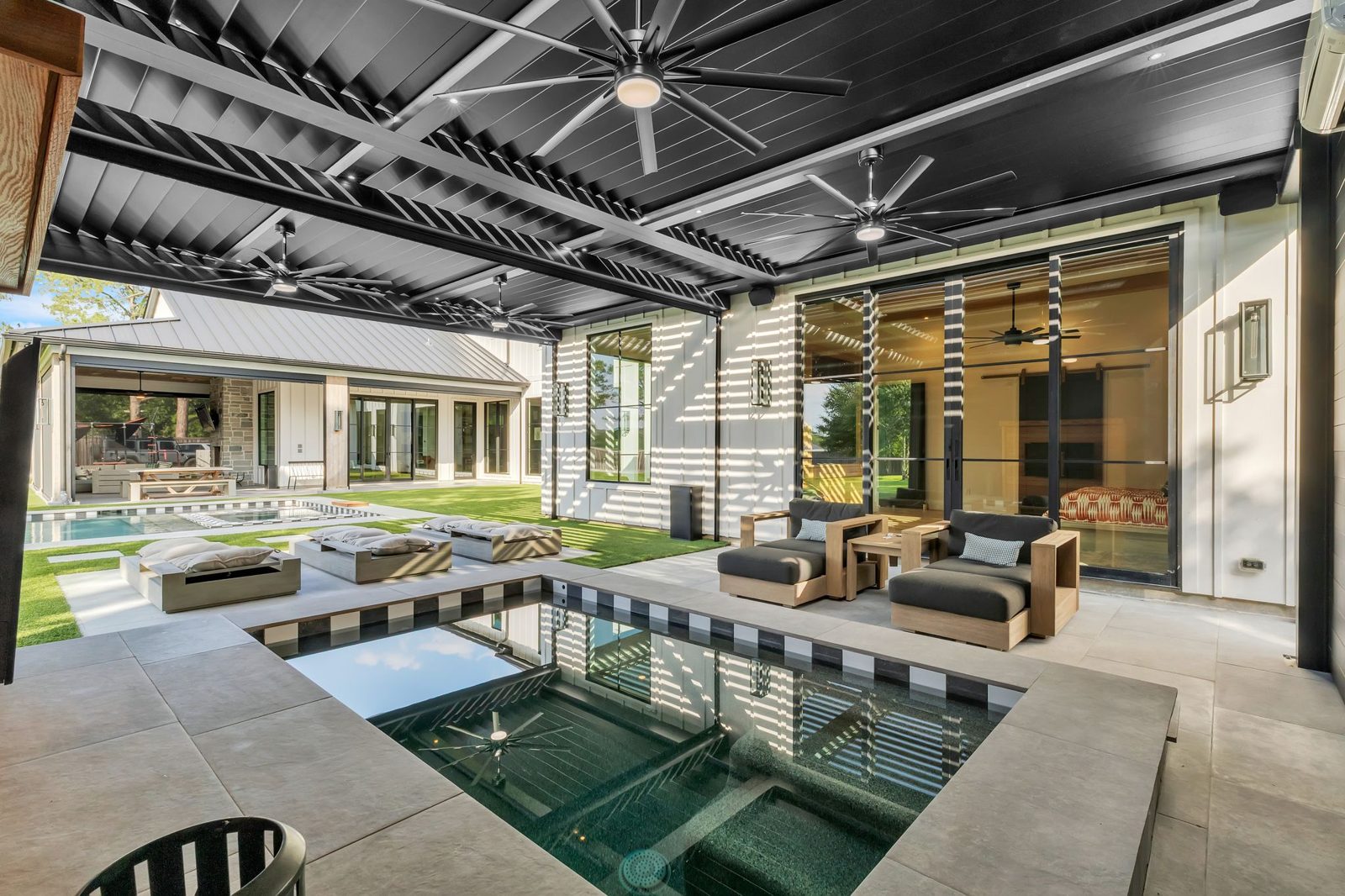 Black Azenco R-BLADE motorized louvered pergola over a Texas poolside patio with privacy walls and screens